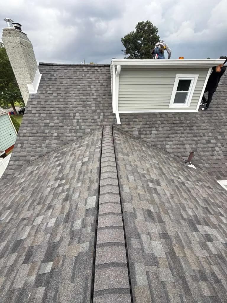 Completed architectural shingle roof replacement with multi-tone grey shingles and new ridge cap in New Jersey